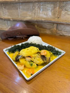 Moqueca de peixe com camarão borbulhando na panela de barro — especialidade de frutos do mar no Botequim Canto do Peixe em Niterói
